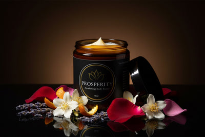 The open jar surrounded by rose petals, jasmine, lavender, and orange peel