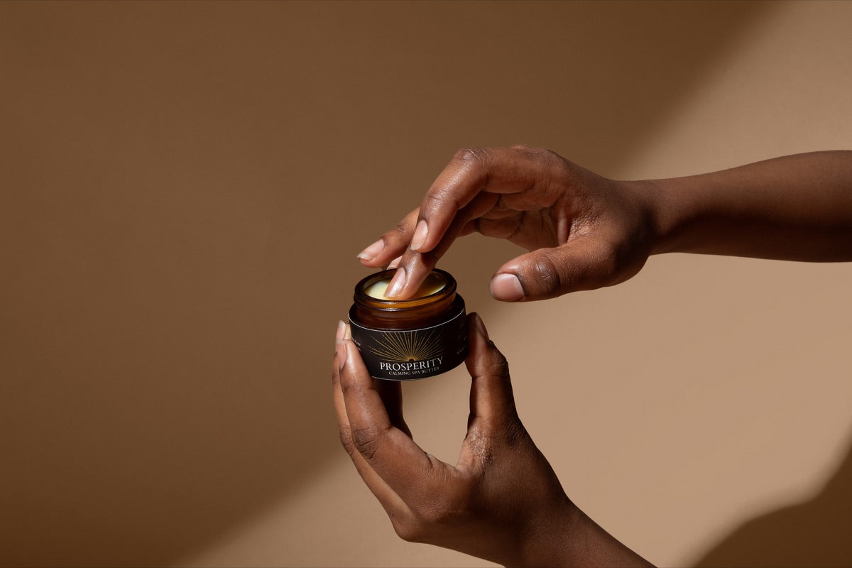 Two hands holding an open jar of Prosperity Butter