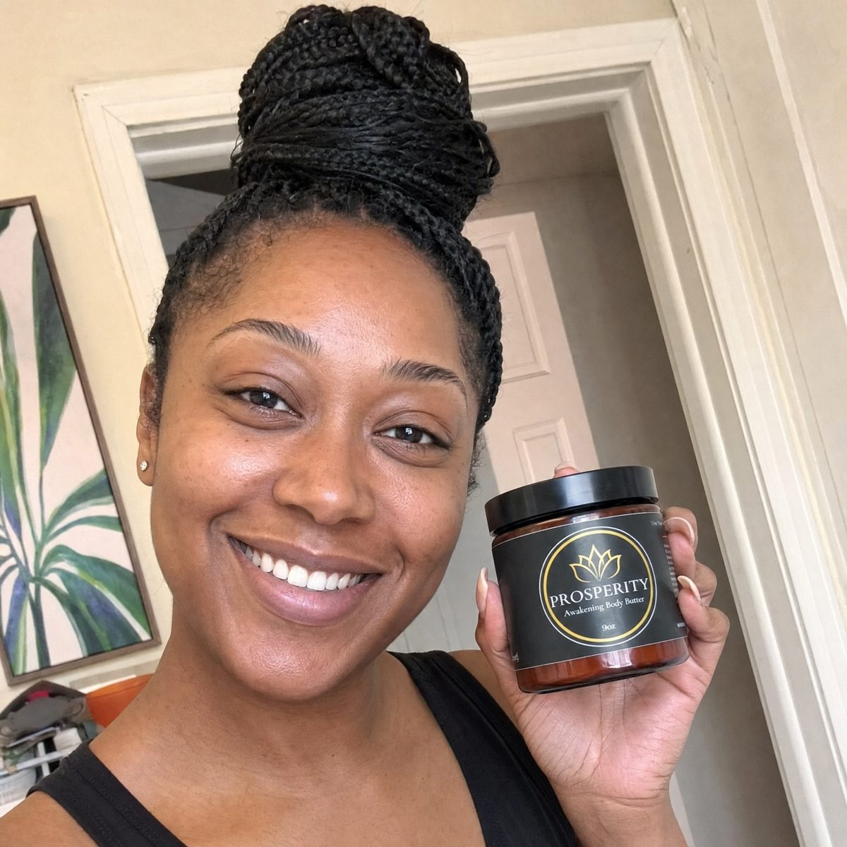 A smiling woman holding her jar of Prosperity Butter